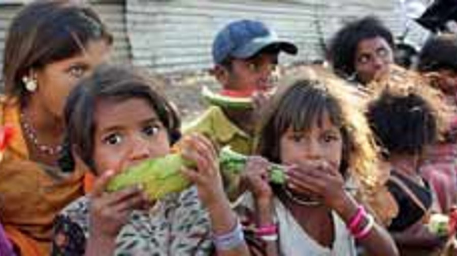 Niños africanos y adultos que se sientan en la calle y comen. © TheFinalMiracle - Fotolia.com